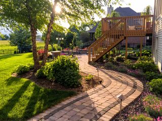 garden layout ideas: curved path leading to steps and seating area
