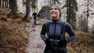 A woman and a man walking through a forest