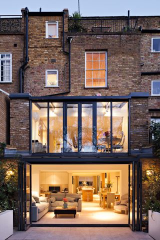 two storey glass extension attached to terraced house by aprops