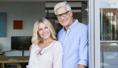 Portrait of smiling mature couple at the balcony at home
