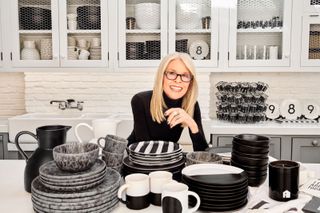 diane keaton in a white kitchen with plates in front of her