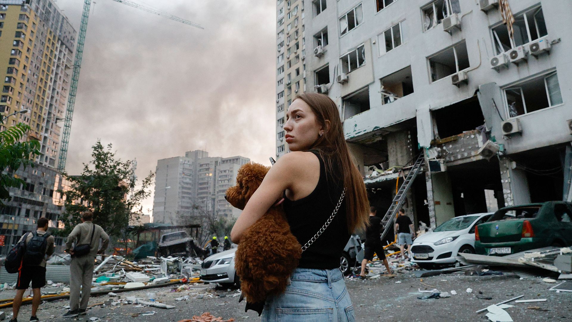 
                                A woman stands with her dog in the aftermath of a Russian drone strike on a residential building in Kyiv, Ukraine
                            
