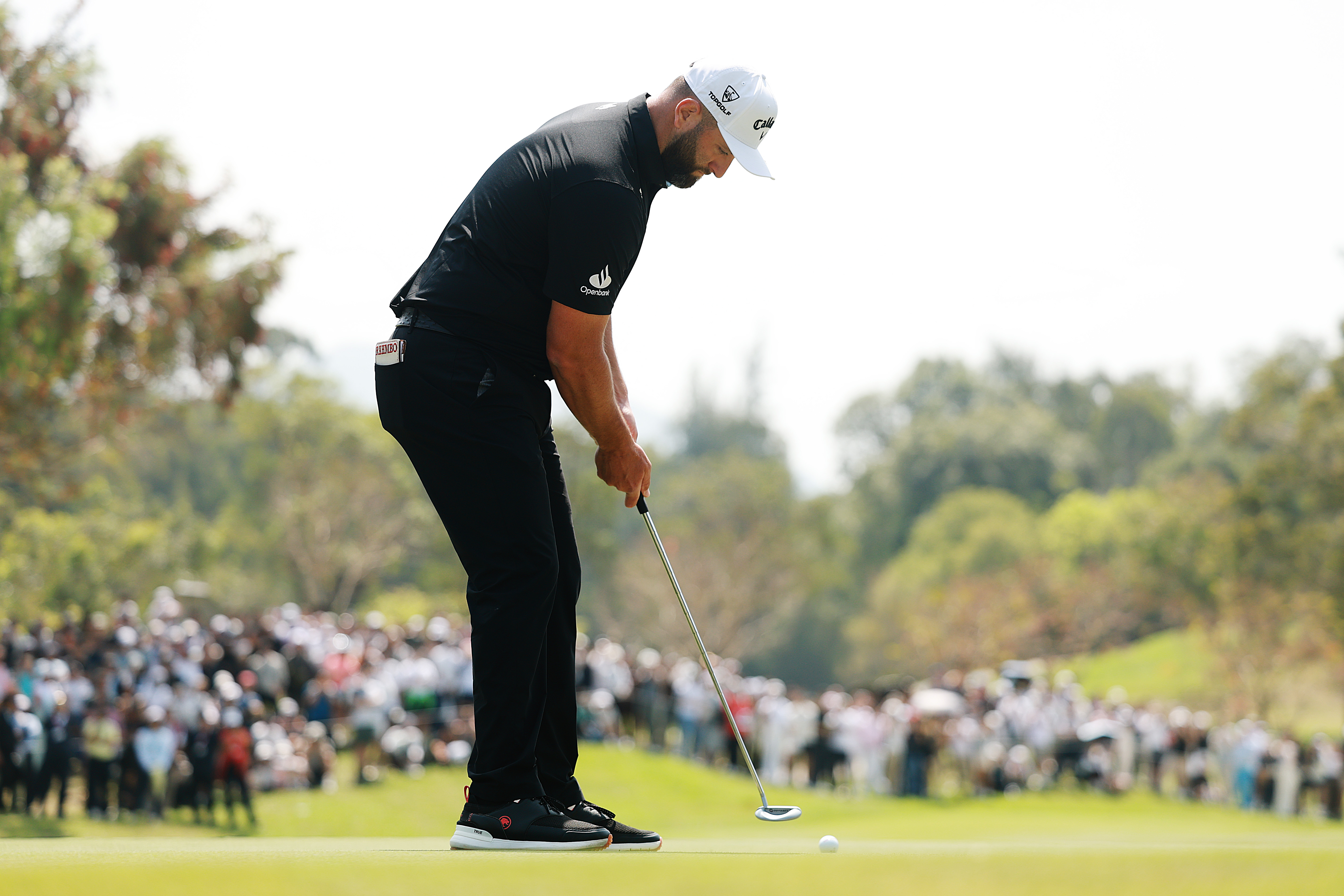 Jon Rahm hits a putt