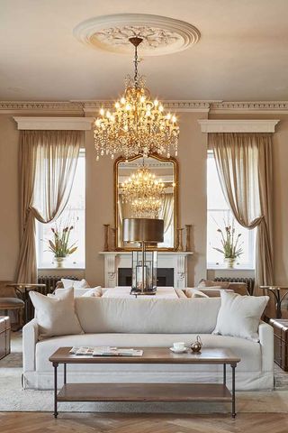 Lounge area with pale furniture, coffee table and chandelier