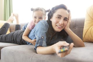 Mother and little girl watching television