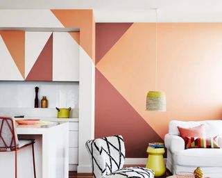 A red white and orange color blocked feature wall in living room with continuation into kitchen