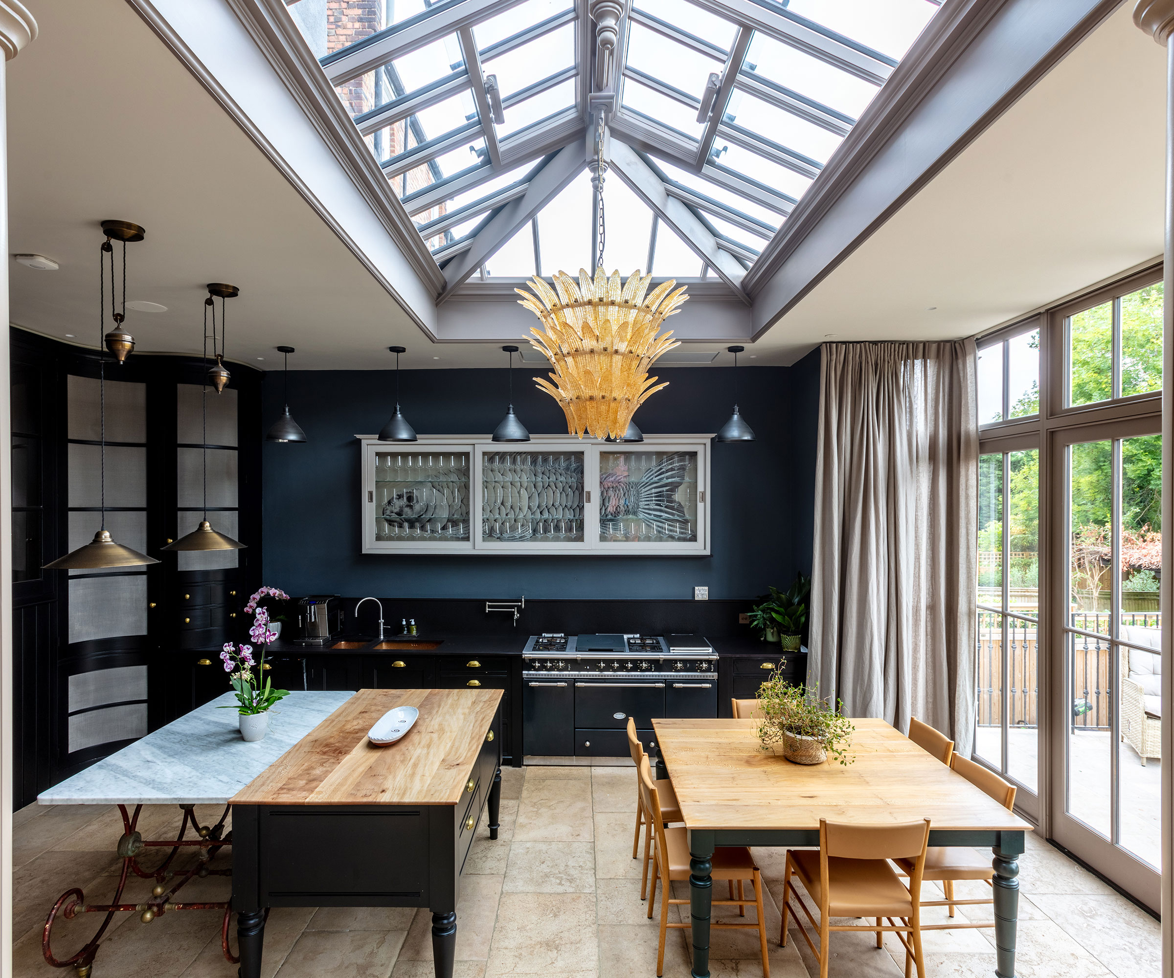 orangery kitchen with navy blue walls and wide plank flooring