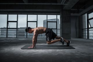 How to workout at home: a man performs mountain climbers in a High Intensity Interval Training workout