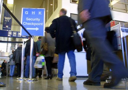 Passengers walk through a security checkpoint.