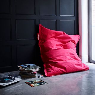 room with black wall and red beanbag and record player and music records