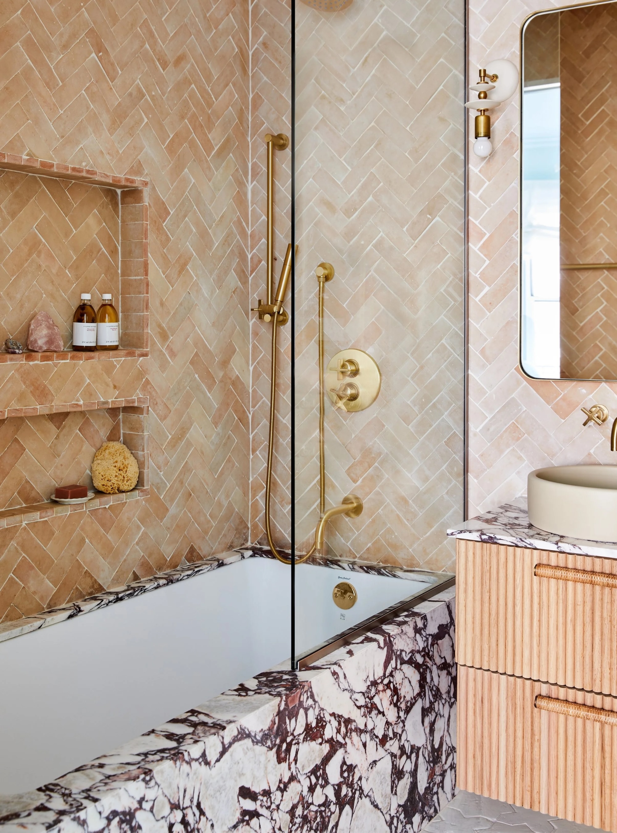Purple veined marble bath with terracotta wall tiles