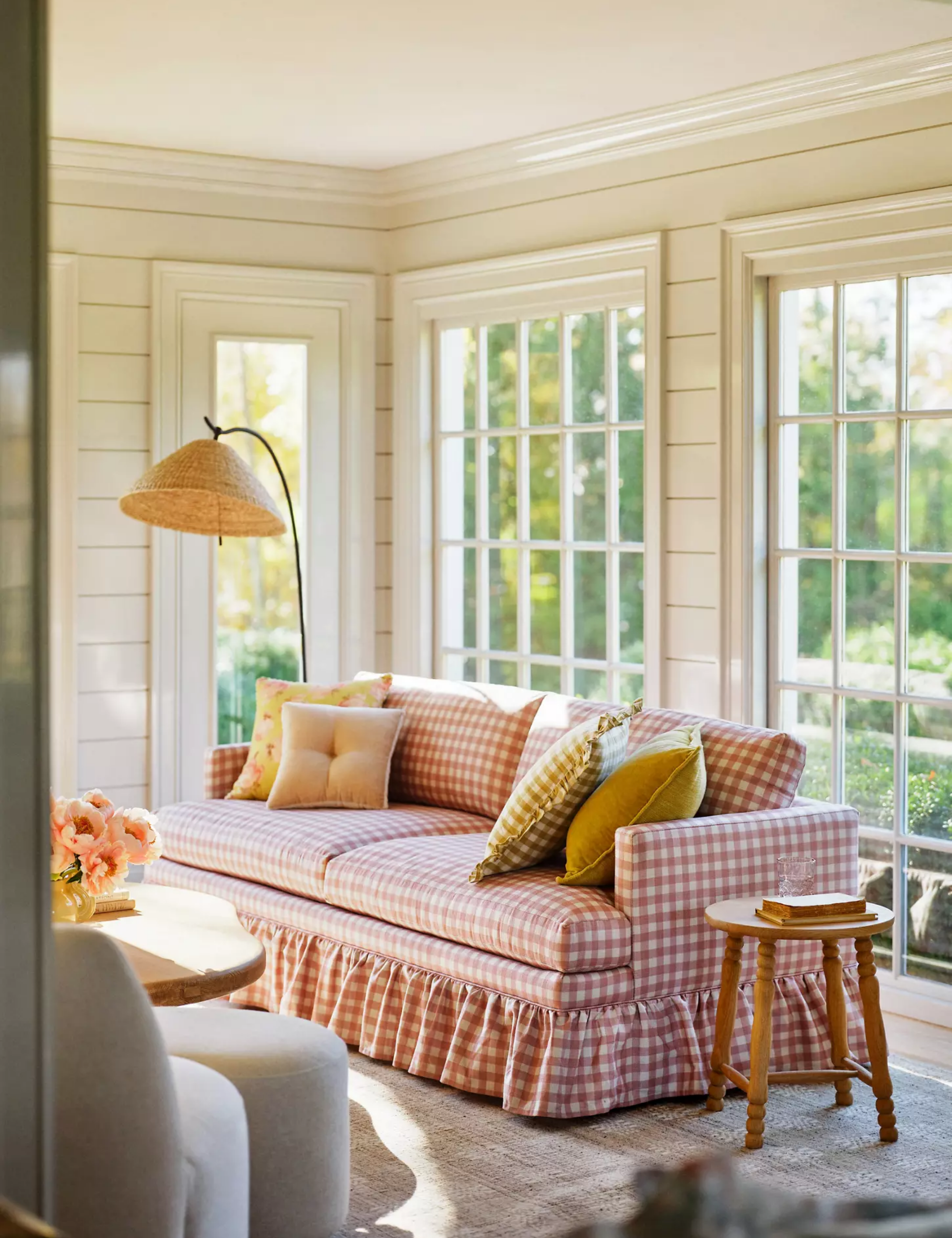 dining room and sofa from the curated cottage anthropologie collection with rustic beams and a farmhouse style dining table and slipcovered chairs