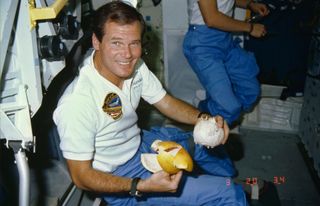 Bill Nelson, STS 61-C payload specialist, prepares to enjoy a freshly peeled grapefruit on board the Space Shuttle Columbia, on Jan. 15, 1986.