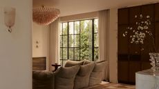 neutral living room with pink-tinted, textured glass light fittings and a large pink chandelier