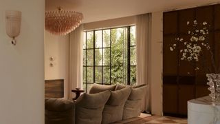 neutral living room with pink-tinted, textured glass light fittings and a large pink chandelier