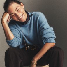 Woman in blue sweater and brown pants
