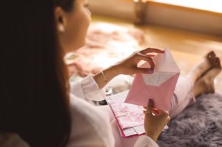 woman opening pink letter