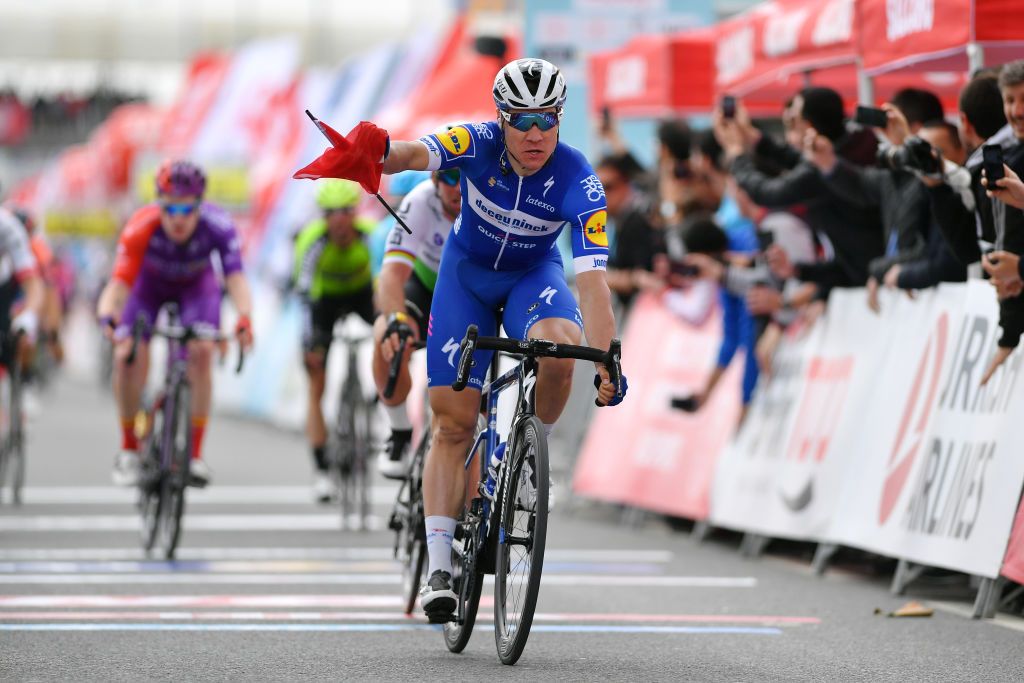 Fabio Jakobsen crosses the line with a Turkish flag in his hand after it caught his hand during the sprint