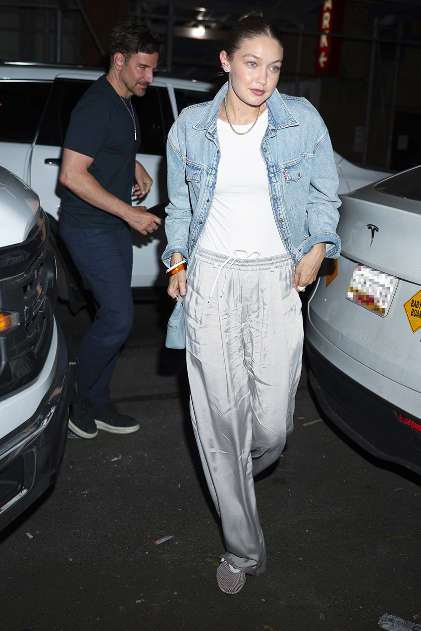 Gigi Hadid wearing a denim jacket, white T-shirt, and satin pull-on pants in NYC