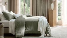 Boll & Branch fall bedding in taupe and white in a luxe bedroom with velvet floor to ceiling taupe curtains and bright crittal windows