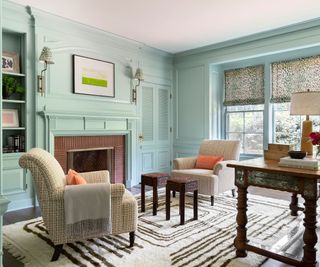 library with aqua walls fireplace and two armchairs