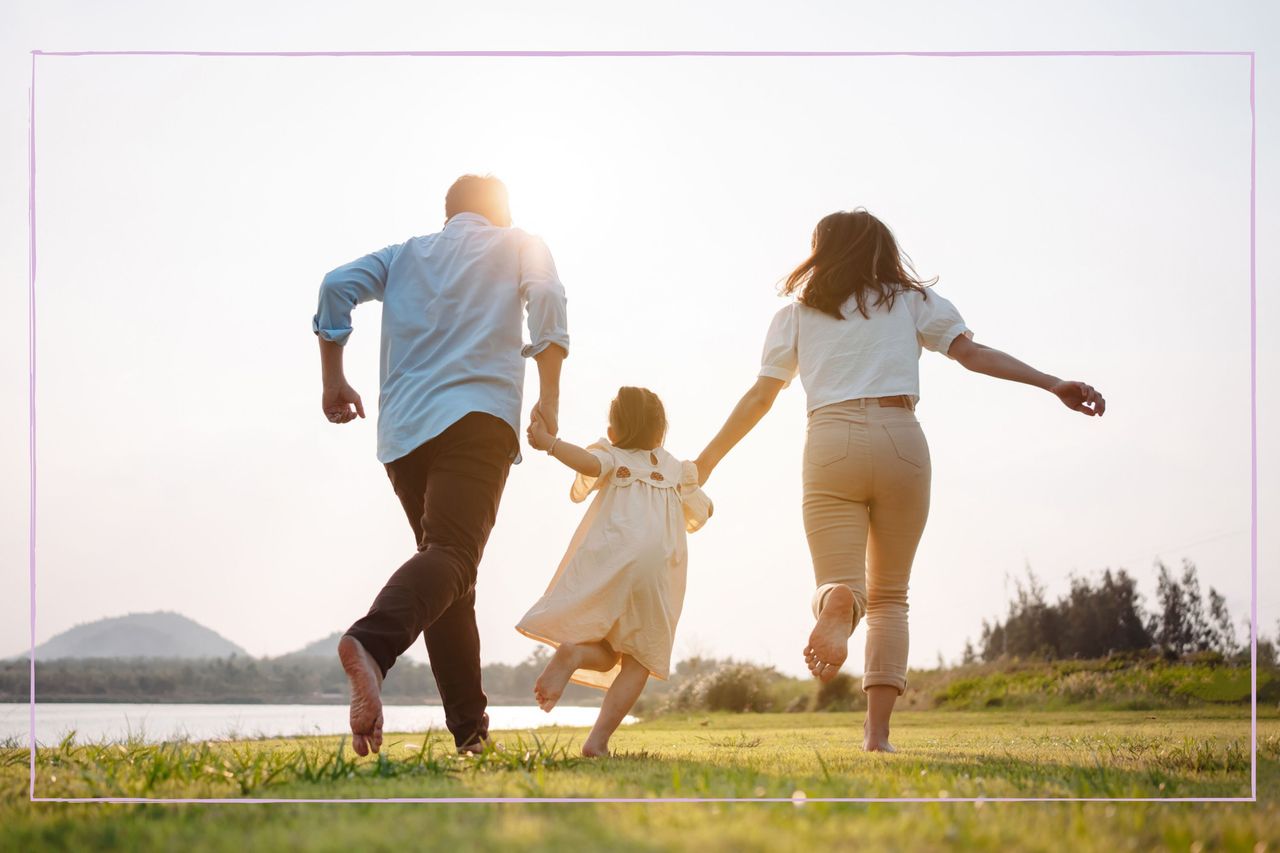 Only child running while holding hands of a parent on each side