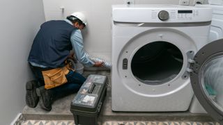 A man installing a washer - How to install a washer-dryer combo