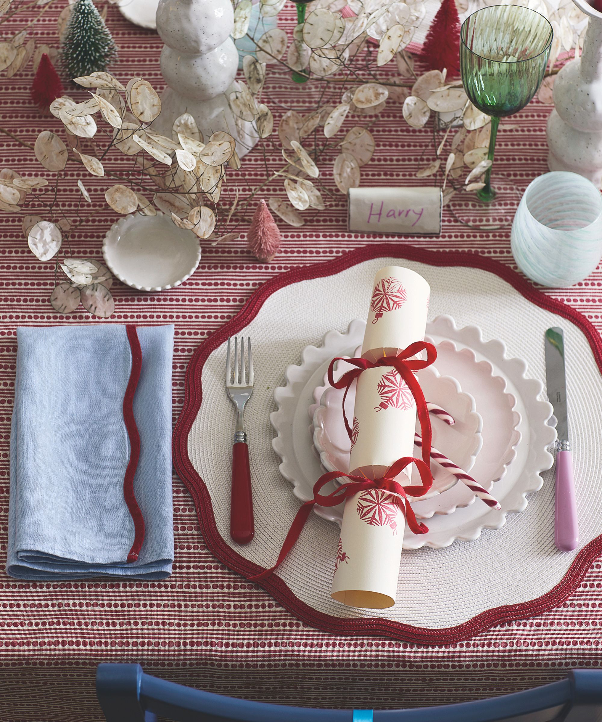 Red and white themed Christmas table setting with cracker and candy cane
