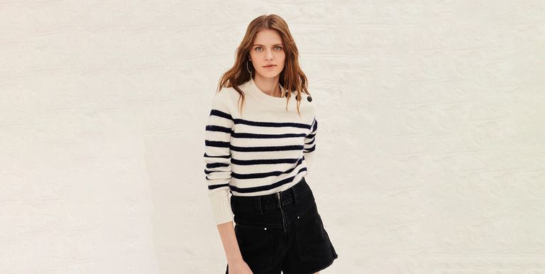 Modeling wearing Ba&sh black and white stripy jumper against a pale grey brick wall. Ba&sh is one of our picks of the best French clothing brands