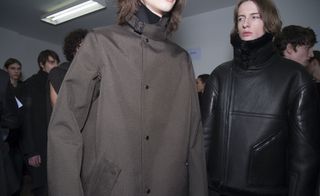 Torso photo of two models - one wearing brown coat and one wearing black coat