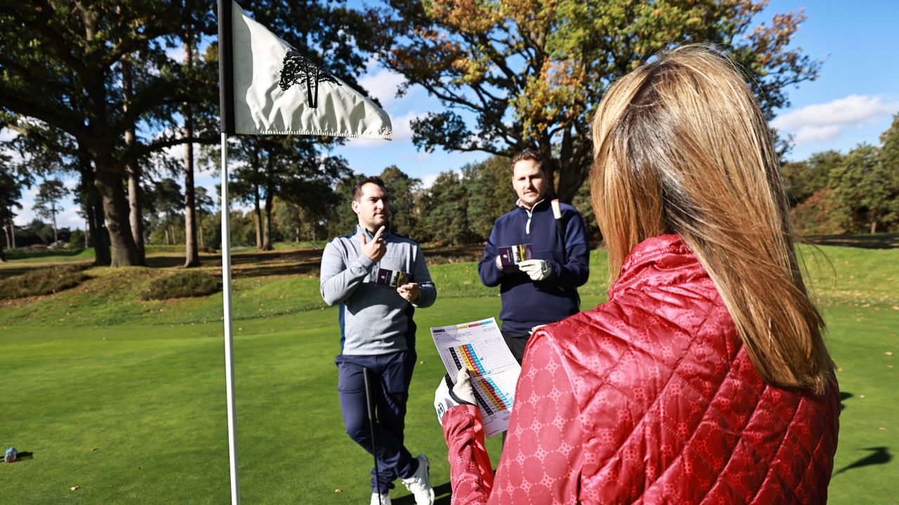 Golfers marking cards on the green