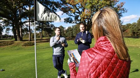 Golfers marking cards on the green