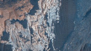 A series of brown, dark blue and white streaks across the surface of Mars