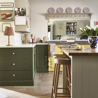 Green kitchen with shaker cupboards and a kitchen island.
