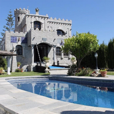 grey castle villa with swimming pool and tree