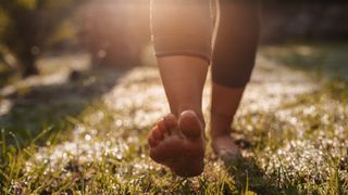 Young woman doing walk-meditation in her garden