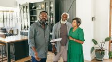 An older couple talk with a Realtor in the kitchen of a house for sale.