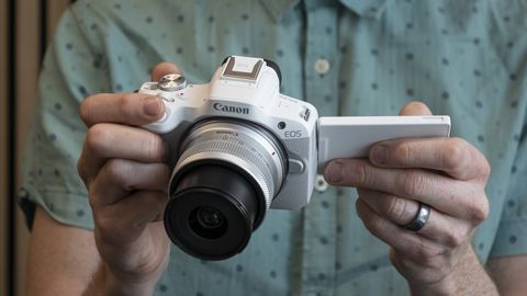 Canon EOS R50 in the hand with screen flipped out