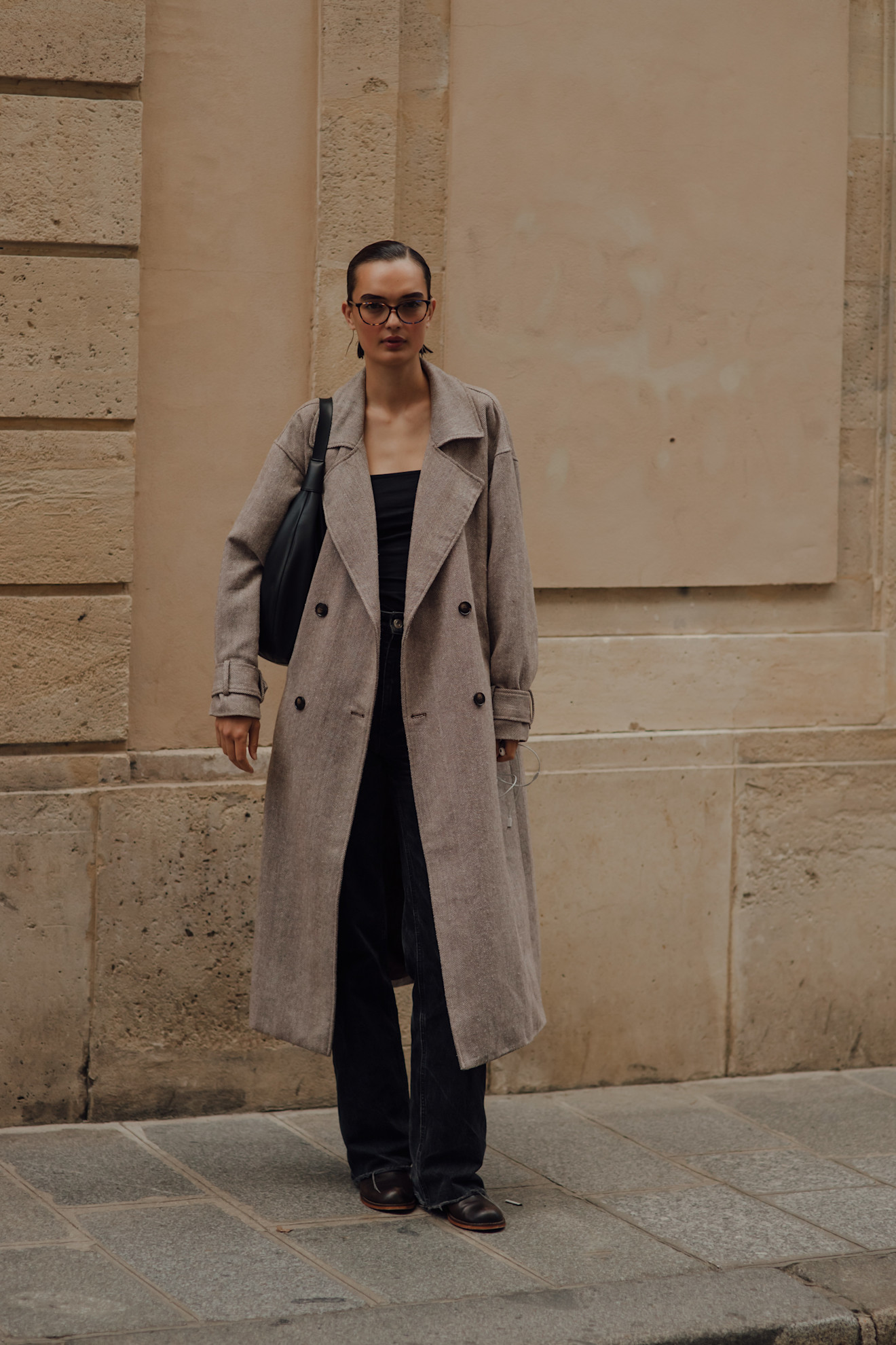 woman wearing trench coat, black top, and black jeans, and boots