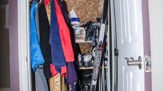 A messy closet with skis and other gear
