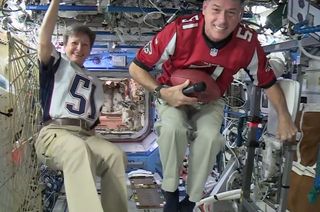 Astronauts Peggy Whitson and Shane Kimbrough wear the jerseys of the Super Bowl LI teams – the New England Patriots and Atlanta Falcons – on board the International Space Station. 