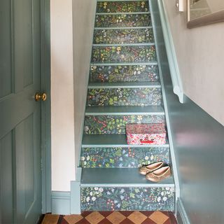 grey painted staircase with wallpapered risers