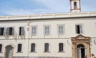 Exterior of the L’Iglesia Hotel — El Jadida, Morocco with cream stone walls and wooden window shutters