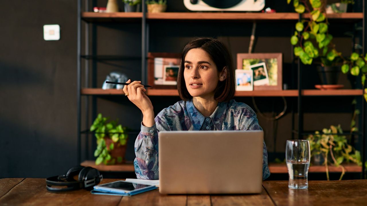 A woman takes a video call from her home office