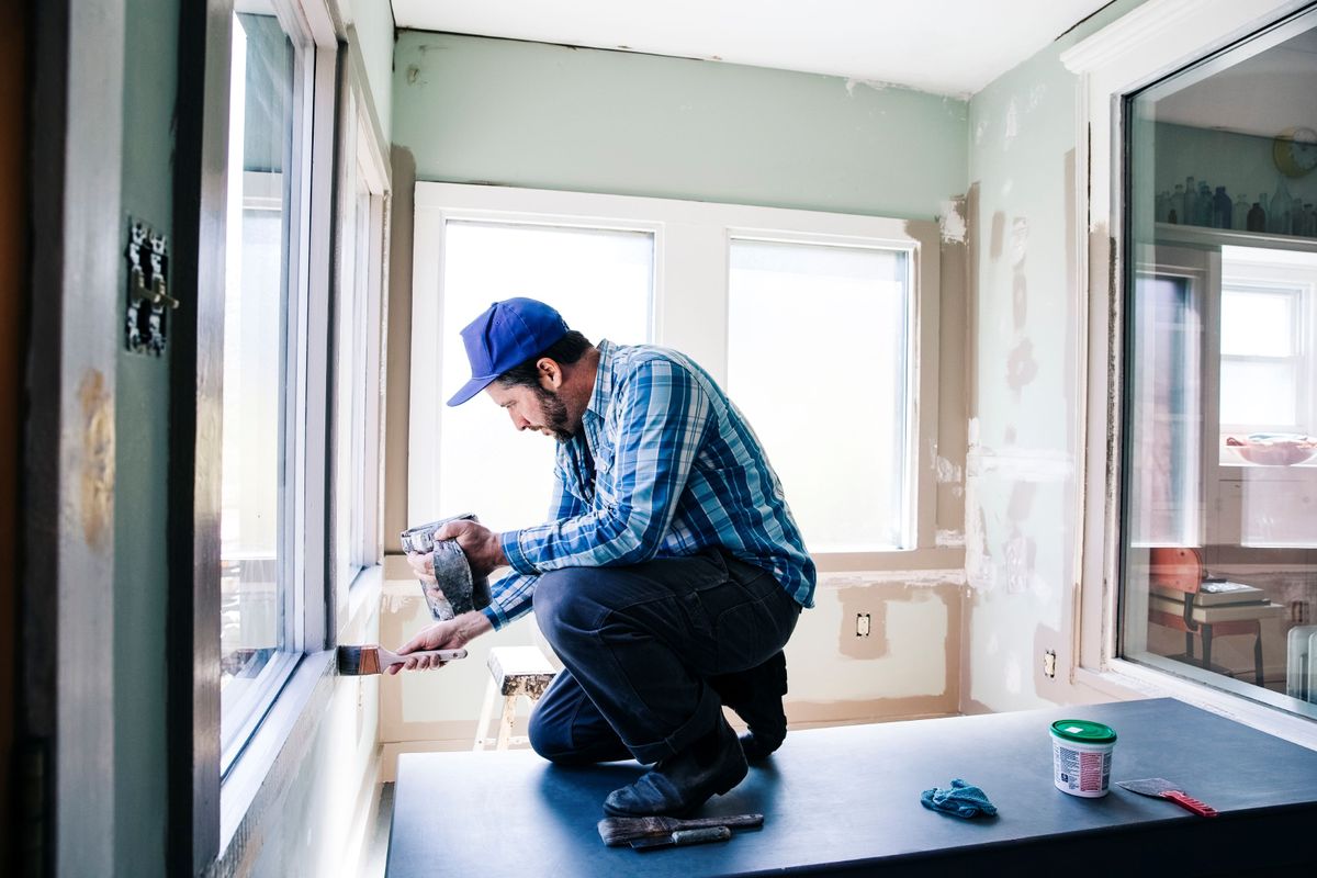 A builder installing double glazing into a window