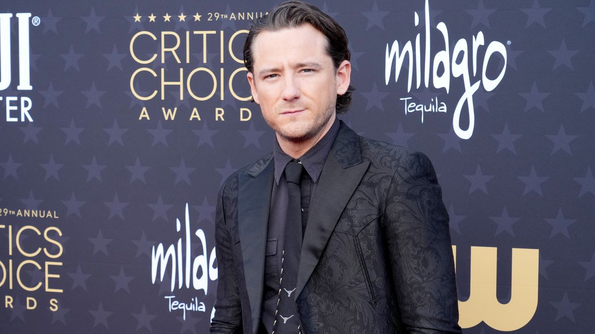 Lewis Pullman poses for pictures on a Critics Choice Awards red carpet