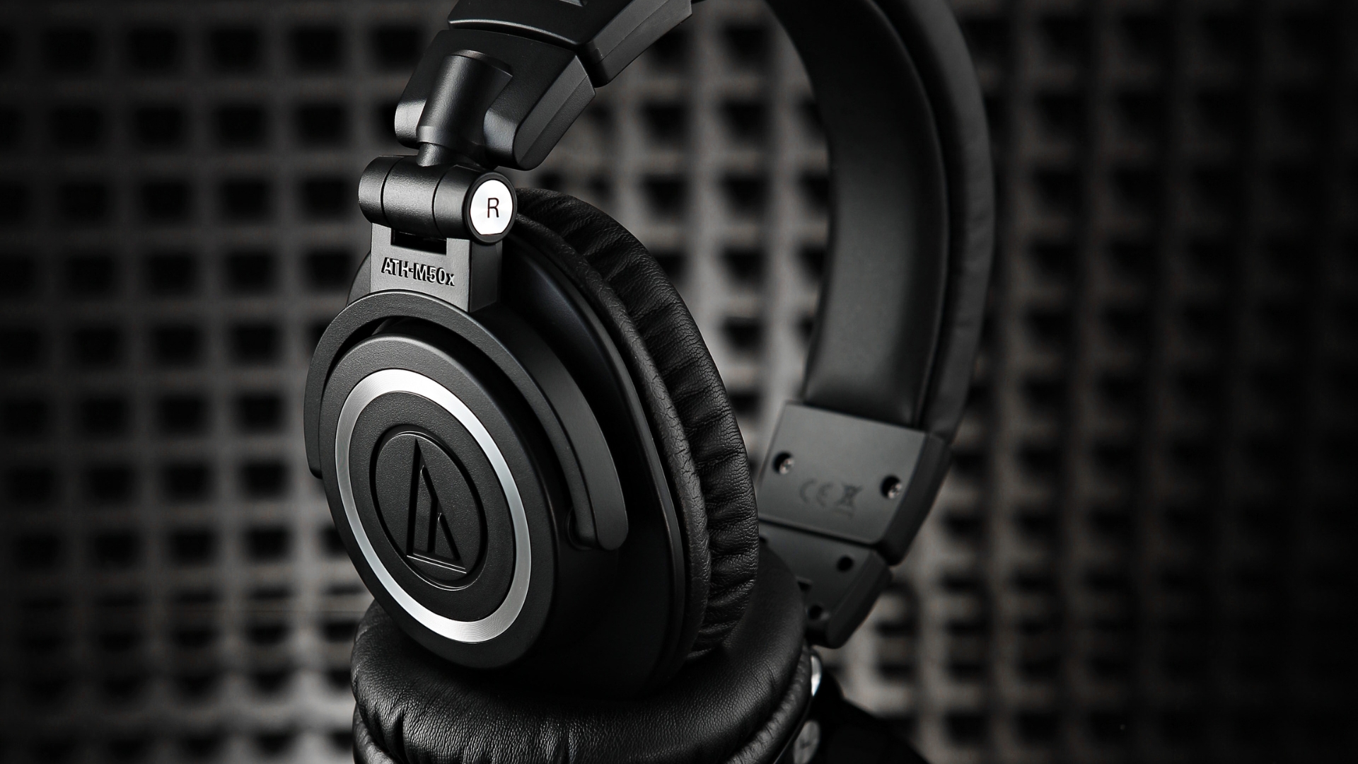 A pair of Audio-Technica ATH-M50x headphones in an acoustically treated room