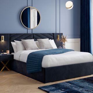 Double bed with white and blue bedding in blue tone bedroom