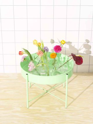 Flowers on bright green tray table, part of Ikea 80th anniversary collection reissues of vintage designs
