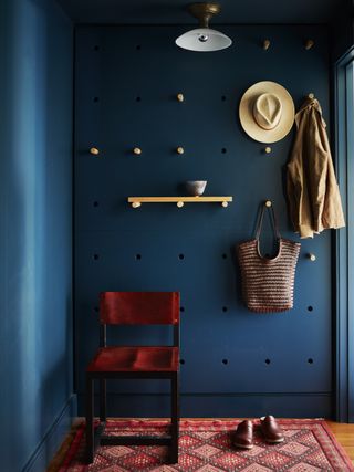 A pegboard used as wall hanging storage in an entryway